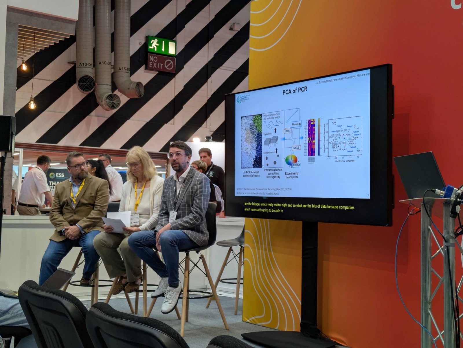 Craig Spencer-Smith speaking on a panel at the Resource and Waste Management Expo, beside a screen showing polymer recycling research